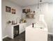 Modern kitchen featuring floating shelves, white cabinets, and a beverage refrigerator at 1345 W 67Th Pl, Denver, CO 80221