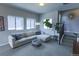 Bright living room with a large sofa, oversized windows, and easy access to the staircase at 1345 W 67Th Pl, Denver, CO 80221
