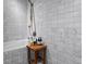 Well-lit bathroom with tiled walls, a soaking tub, and a small wooden table at 1750 Wewatta St # 700, Denver, CO 80202