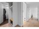 Well-lit hallway with tiled entryway, laundry closet, and access to other rooms at 1750 Wewatta St # 700, Denver, CO 80202