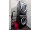 Compact laundry area featuring a stacked washer and dryer, maximizing space with some storage at 1750 Wewatta St # 700, Denver, CO 80202
