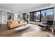 Contemporary living space with floor-to-ceiling windows and city vistas, hardwood flooring, and sleek furnishings at 1750 Wewatta St # 700, Denver, CO 80202
