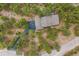 Aerial view showcases the property's private driveway, mature trees, and architectural roof design at 2857 Hiwan Dr, Evergreen, CO 80439