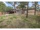 Scenic backyard with mature trees, and an exterior view of the home and deck area at 2857 Hiwan Dr, Evergreen, CO 80439