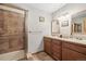 Bathroom featuring tile shower, double vanity and warm accents at 2857 Hiwan Dr, Evergreen, CO 80439
