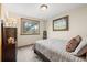 Cozy bedroom featuring warm tones, artwork, and a window with views to the winter outdoors at 2857 Hiwan Dr, Evergreen, CO 80439