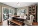 Formal dining room featuring natural light, a dark wood table, bench, and access to the back deck at 2857 Hiwan Dr, Evergreen, CO 80439