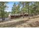 A view of the home with stone accents from the side, showing driveway access to the garage at 2857 Hiwan Dr, Evergreen, CO 80439