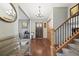 Inviting foyer with hardwood floors, a wooden staircase, and a decorative chandelier at 2857 Hiwan Dr, Evergreen, CO 80439