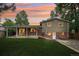 Backyard view featuring a covered patio, spacious lawn, fire pit, and mature trees, ideal for outdoor living at 6320 E Asbury Ave, Denver, CO 80224