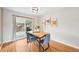 Dining room features hardwood floors, sliding door to yard and vintage artwork at 6320 E Asbury Ave, Denver, CO 80224