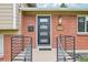 Close-up of a modern front door with sleek metal railings and brick accents at 6320 E Asbury Ave, Denver, CO 80224
