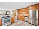 Well-appointed kitchen with stainless appliances, maple cabinets, and tile flooring at 6320 E Asbury Ave, Denver, CO 80224