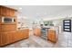 Updated kitchen with gas range, stone countertops, tile floors, and maple cabinets at 6320 E Asbury Ave, Denver, CO 80224