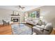 Bright living room with hardwood floors, a decorative fireplace, and comfortable seating at 6320 E Asbury Ave, Denver, CO 80224
