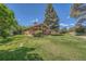Expansive backyard featuring lush green lawn, mature trees, and a tranquil setting, ideal for outdoor enjoyment at 8164 Flower Cir, Arvada, CO 80005