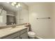 Bathroom featuring a sink, vanity, toilet and a large mirror at 8164 Flower Cir, Arvada, CO 80005