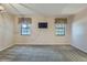 Bright living room with carpet, TV, and two windows with curtains at 8164 Flower Cir, Arvada, CO 80005