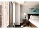 Bedroom detail featuring a large window with city views, a stylish nightstand, and modern artwork at 1133 14Th St # 1820, Denver, CO 80202