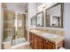Bathroom with a tile shower, double sinks, wood cabinets, and framed mirrors at 860 Bristle Pine Cir # A, Highlands Ranch, CO 80129