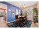 Bright dining room features bold blue accent wall with elegant chandelier and large window at 860 Bristle Pine Cir # A, Highlands Ranch, CO 80129