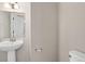 Neutral powder bath featuring pedestal sink, mirror, and toilet at 19629 W 93Rd Dr # C, Arvada, CO 80007