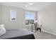 Bright bedroom featuring large windows with neighborhood views, a bed, and a workspace at 19629 W 93Rd Dr # C, Arvada, CO 80007