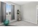 Bright bedroom featuring a large window with neighborhood views and a decorative plant shelf at 19629 W 93Rd Dr # C, Arvada, CO 80007