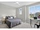 Bright bedroom featuring a ceiling fan, large windows with neighborhood views, and a comfortable bed at 19629 W 93Rd Dr # C, Arvada, CO 80007