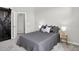 Comfortable bedroom with a sliding barn door, a plush bed with stylish linens and side tables at 19629 W 93Rd Dr # C, Arvada, CO 80007