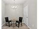 Cozy dining area featuring a modern chandelier, and a round table with two chairs at 19629 W 93Rd Dr # C, Arvada, CO 80007