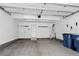 Spacious and clean garage with white walls, concrete floor, and blue recycling bins at 19629 W 93Rd Dr # C, Arvada, CO 80007