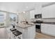 Modern kitchen island with stainless appliances and barstool seating in an open-concept living space at 19629 W 93Rd Dr # C, Arvada, CO 80007