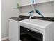 Modern laundry room with updated washer and dryer units and convenient shelving at 19629 W 93Rd Dr # C, Arvada, CO 80007