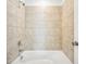 Tiled bathroom shower with a white tub, chrome fixtures, and neutral-toned tiling at 39720 Congress Ln, Elizabeth, CO 80107