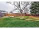 Lush green backyard with mature trees, a walkway, and wood privacy fence for enjoying outdoor living at 10679 Union Way, Broomfield, CO 80021