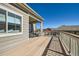 Spacious back deck featuring wood-like flooring, offering ample space for outdoor enjoyment with neighborhood views at 12708 Tamarac St, Thornton, CO 80602