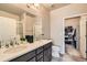 Elegant bathroom boasts a double vanity, large mirror, and a walk-in closet at 12708 Tamarac St, Thornton, CO 80602