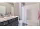 Bathroom featuring a vanity with a sink and a shower-tub combination with white tile surround at 12708 Tamarac St, Thornton, CO 80602