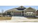 Inviting single-story home featuring a two-car garage, stone accents, and a well-manicured lawn and garden at 12708 Tamarac St, Thornton, CO 80602
