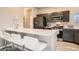 Stylish kitchen features a breakfast bar with seating, stainless steel appliances, and ample counter space at 12708 Tamarac St, Thornton, CO 80602