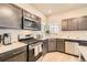 Charming kitchen features stainless steel appliances, stone countertops, and ample cabinet storage space at 12708 Tamarac St, Thornton, CO 80602