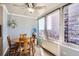 Bright dining area featuring a round wooden table, gray wood floors and sweeping city views through large windows at 789 N Clarkson St # 705, Denver, CO 80218