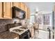 Well-lit kitchen with wooden cabinets, stainless steel appliances, and a dining area at 789 N Clarkson St # 705, Denver, CO 80218