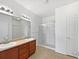 Bright bathroom featuring double sinks, vanity, and a shower with a glass enclosure at 12742 E 104Th Dr, Commerce City, CO 80022