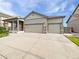 Charming exterior showcasing a three-car garage, stone accents, and well-manicured lawn at 12742 E 104Th Dr, Commerce City, CO 80022