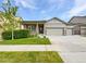 Charming single-story home featuring a three-car garage, covered porch, and well-maintained landscaping at 12742 E 104Th Dr, Commerce City, CO 80022
