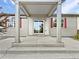 Covered back patio with concrete steps, large windows, and red shutters at 12742 E 104Th Dr, Commerce City, CO 80022