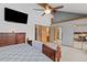 Vaulted bedroom featuring ceiling fan, TV, with adjoining closet and bathroom doors at 7624 S Cove Cir, Centennial, CO 80122