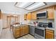 Well-lit kitchen featuring stainless steel appliances, wooden cabinets, and an adjacent dining area at 7624 S Cove Cir, Centennial, CO 80122